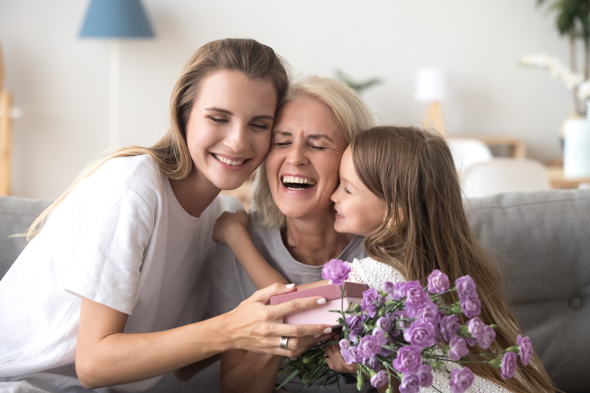 hija-nieta-y-abuela-con-caja-de-regalos-y-flores-en-el-interior
